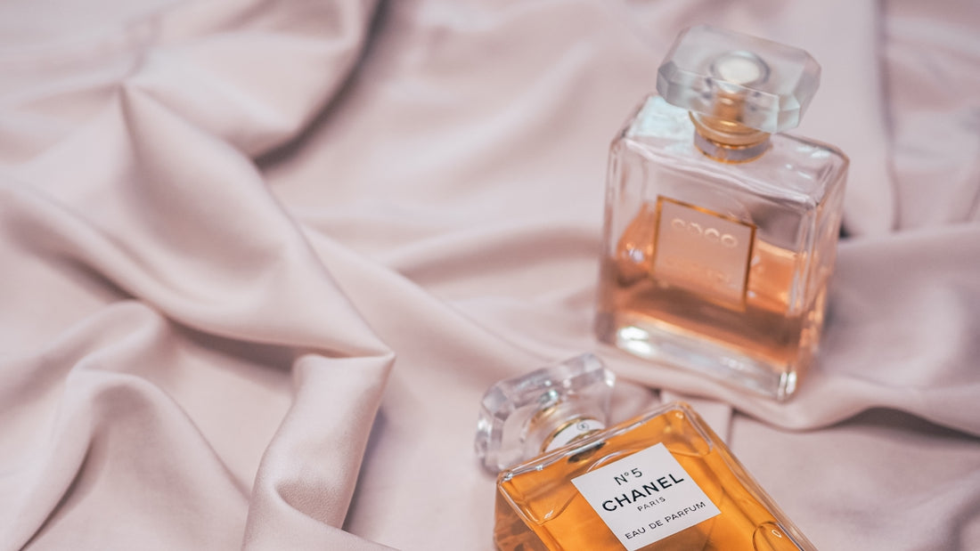 clear glass perfume bottle on white textile