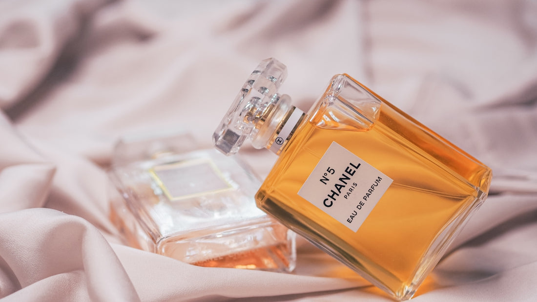 clear glass perfume bottle on white textile