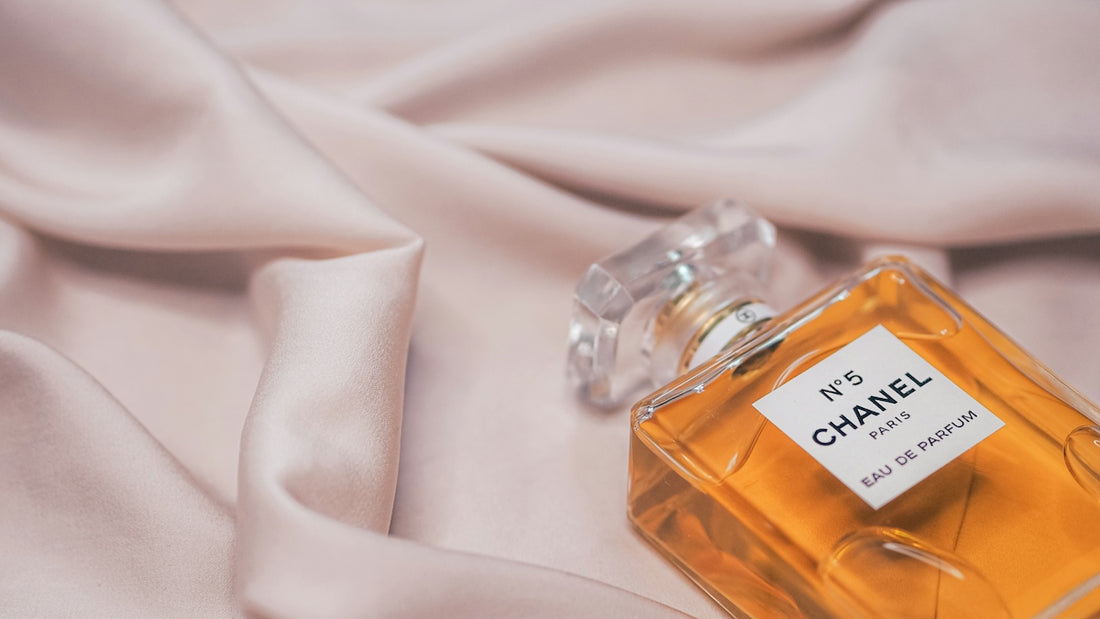 clear glass perfume bottle on white textile