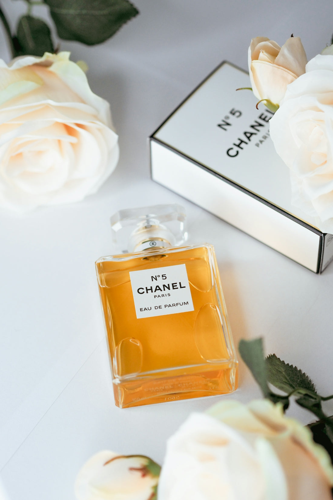 a bottle of perfume next to a box of flowers