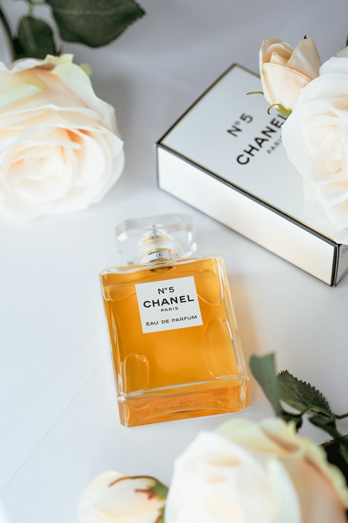 a bottle of perfume next to a box of flowers