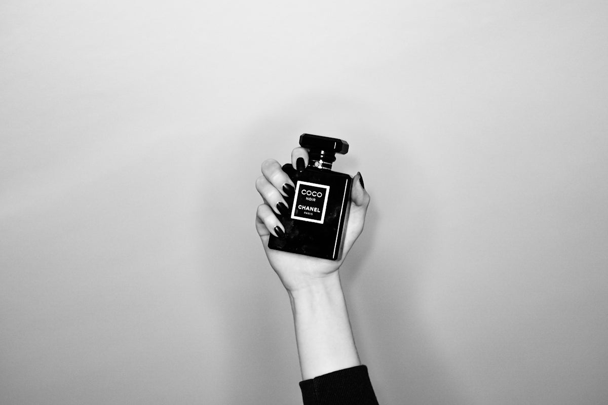 a person holding a bottle of perfume in their hand