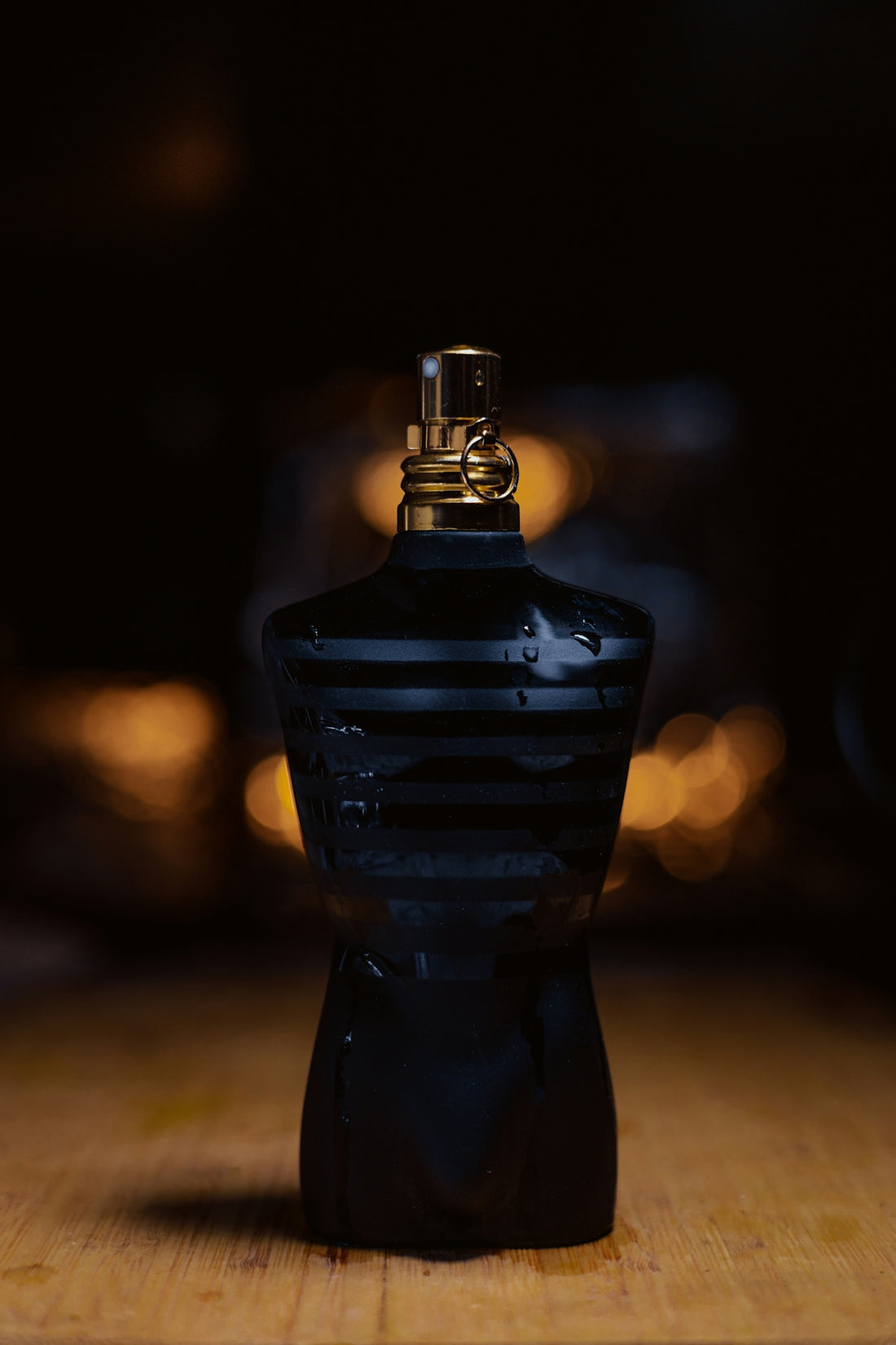 A small black bottle sitting on top of a wooden table