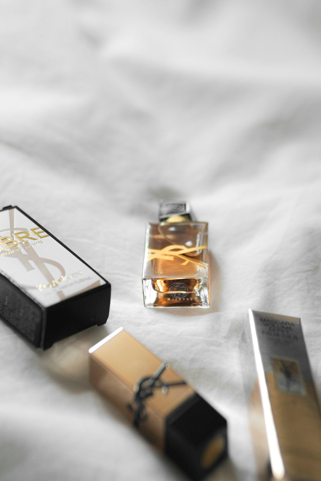 A bottle of perfume sitting on top of a bed