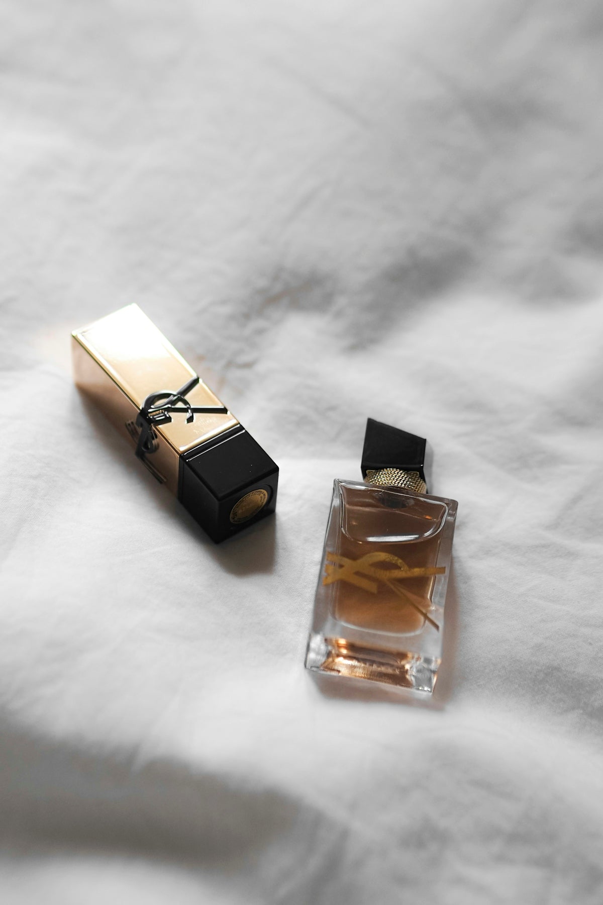A bottle of perfume sitting on top of a bed