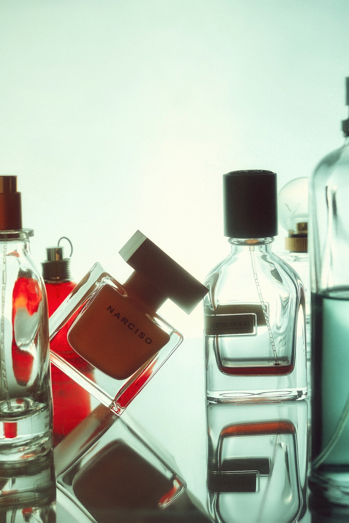 A table topped with bottles of different types of perfume