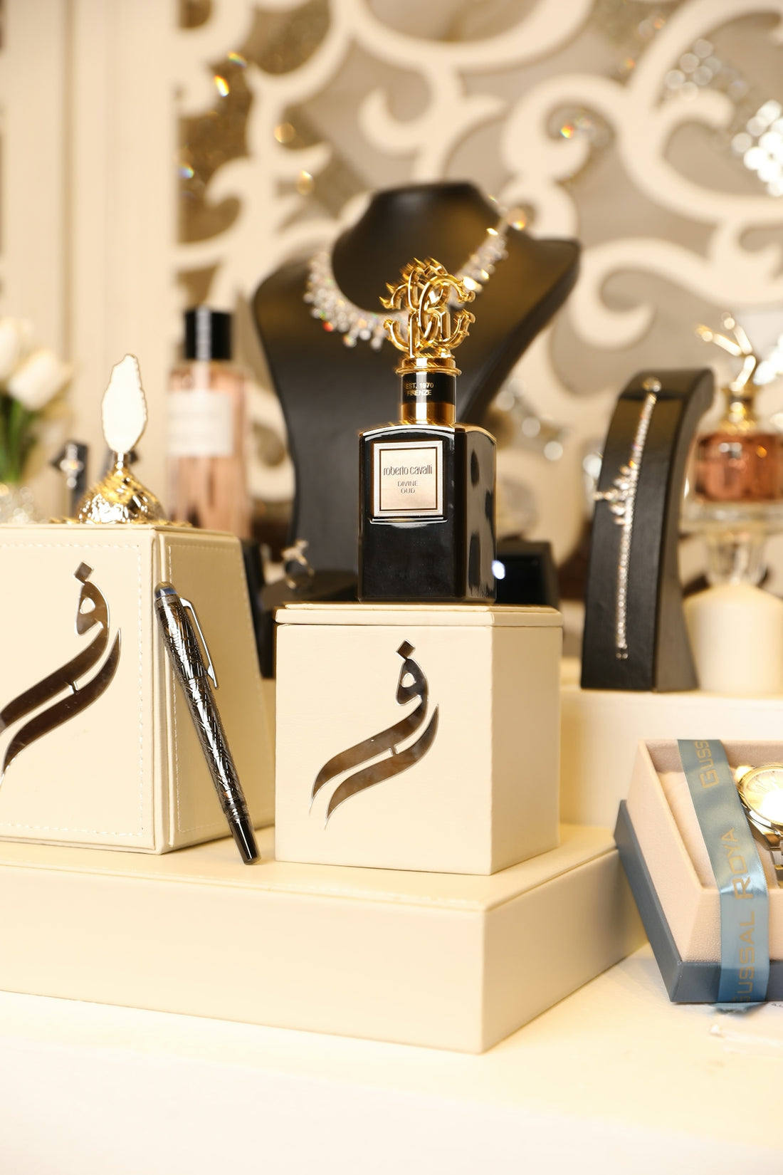 Elegant perfume bottles and jewelry are displayed.