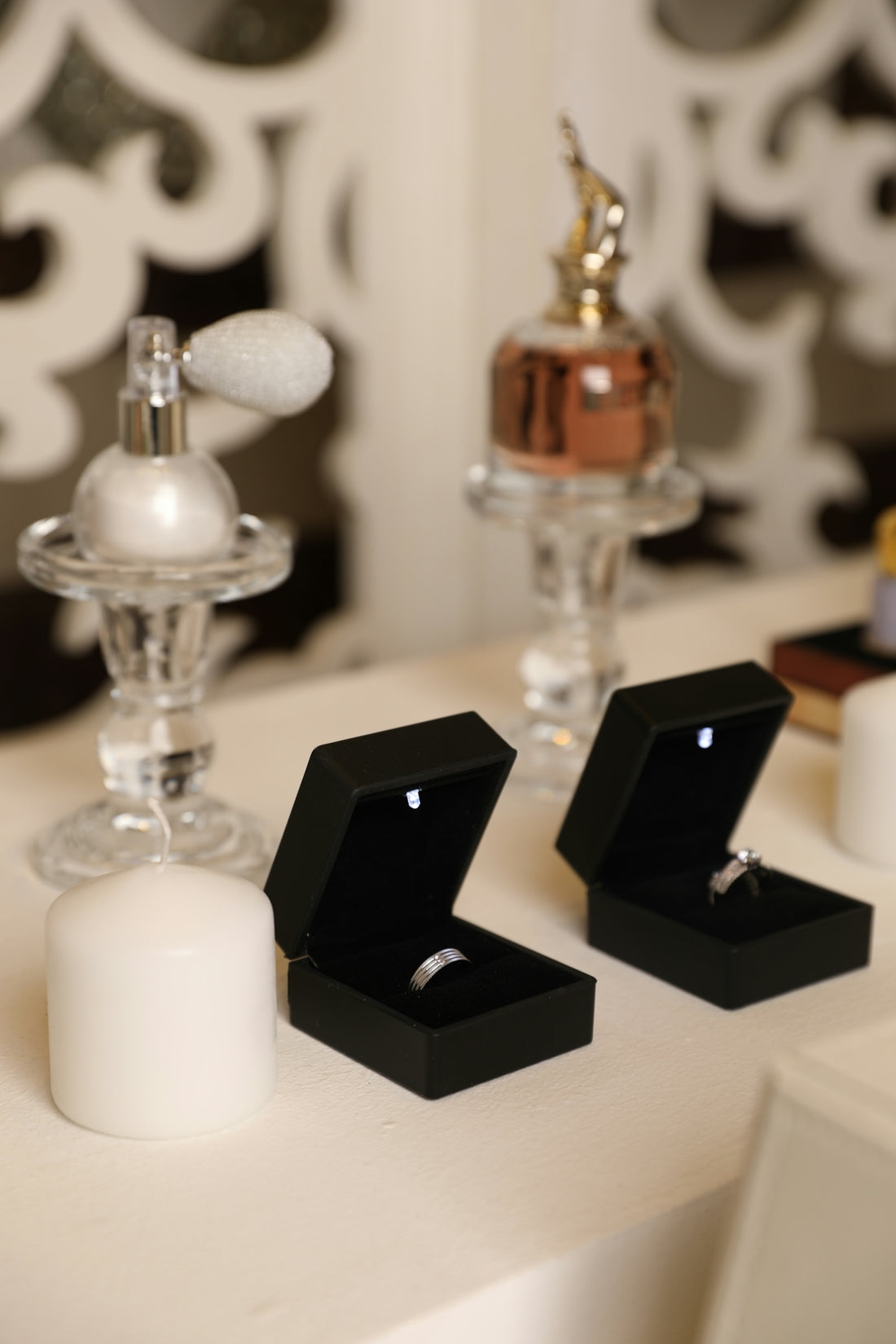 Rings are displayed next to perfume bottles and candles.